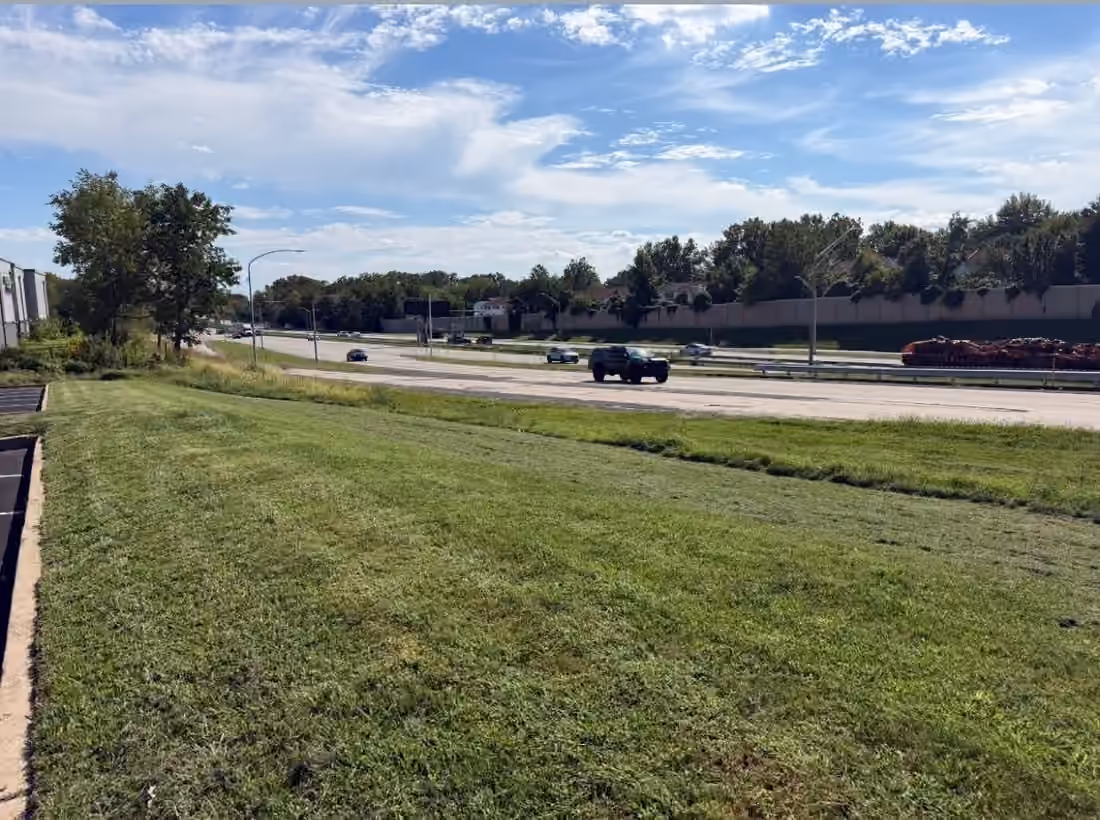 Mowed roadside lawn beside a paved road and sidewalk