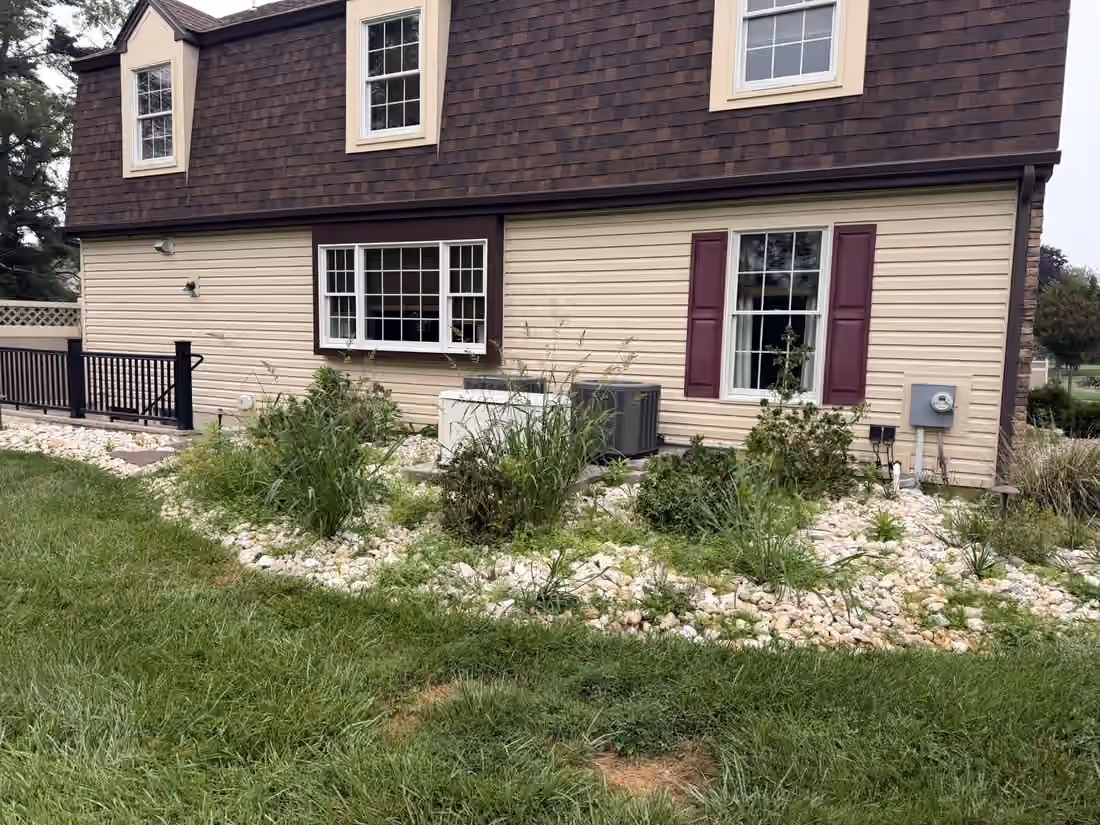 River rock bed with ornamental grasses along the side of the house
